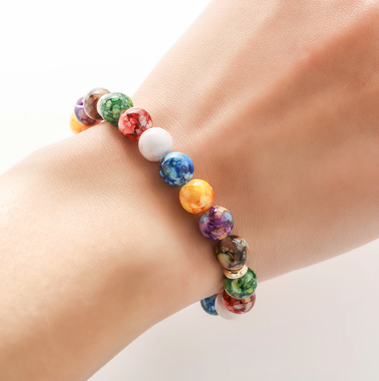 Bracelet perles de couleurs marbrées 7 chakras. Détails produit : Anneaux métal doré. Perles des 7 chakras.