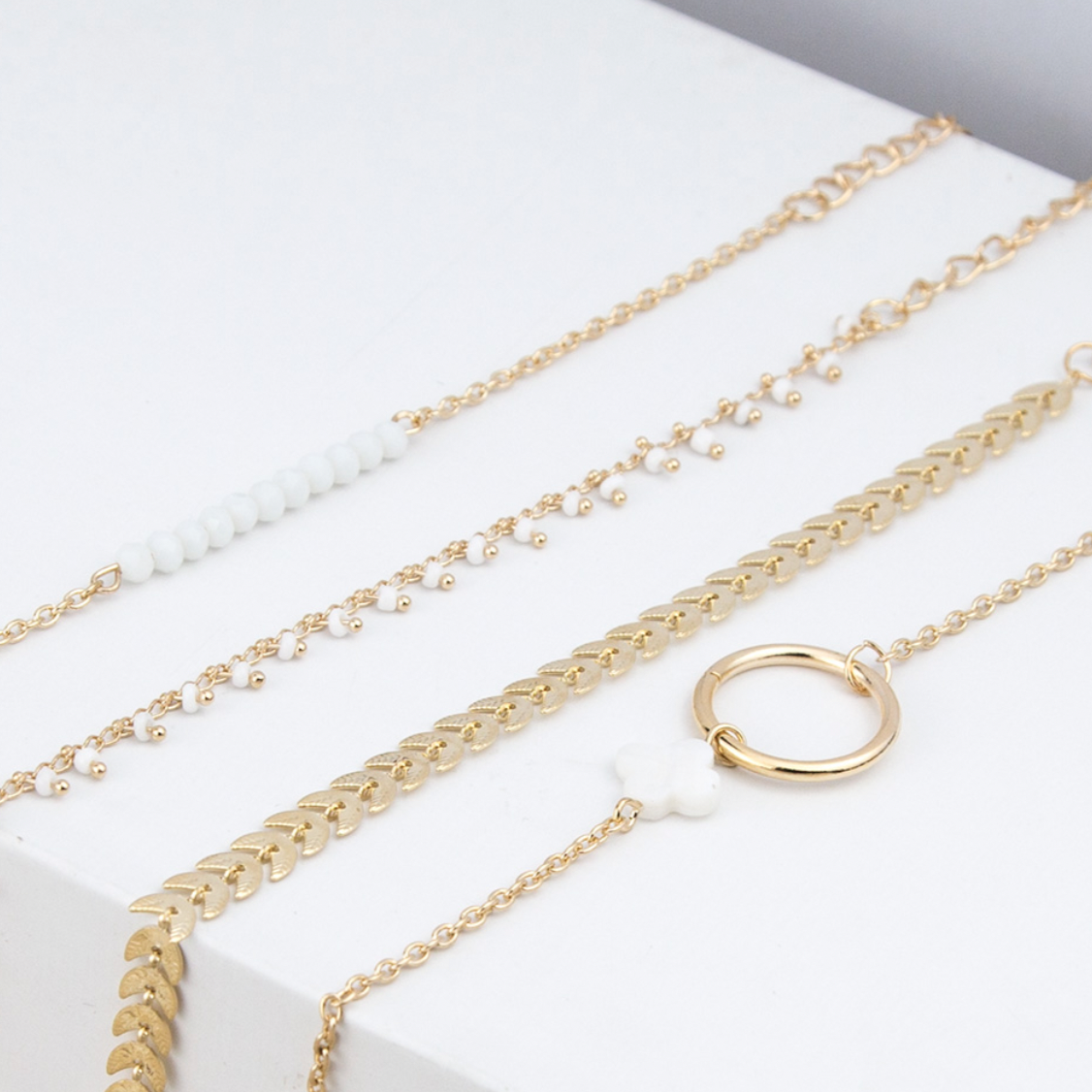 Lot de 4 bracelets dorés feuillage et perles nacrées. Taille des bracelets 17,5 cm + 7 cm.